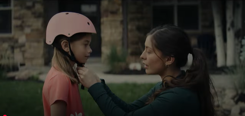 Picture of mother putting bike helmet on child